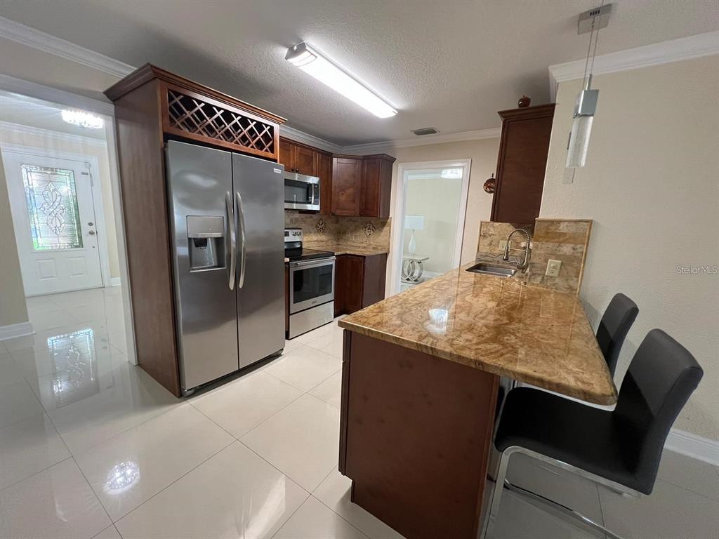 5602 Joyner Road Tampa, FL 33624 - Photo 20 of 28 a kitchen with stainless steel appliances granite countertop a sink refrigerator and microwave