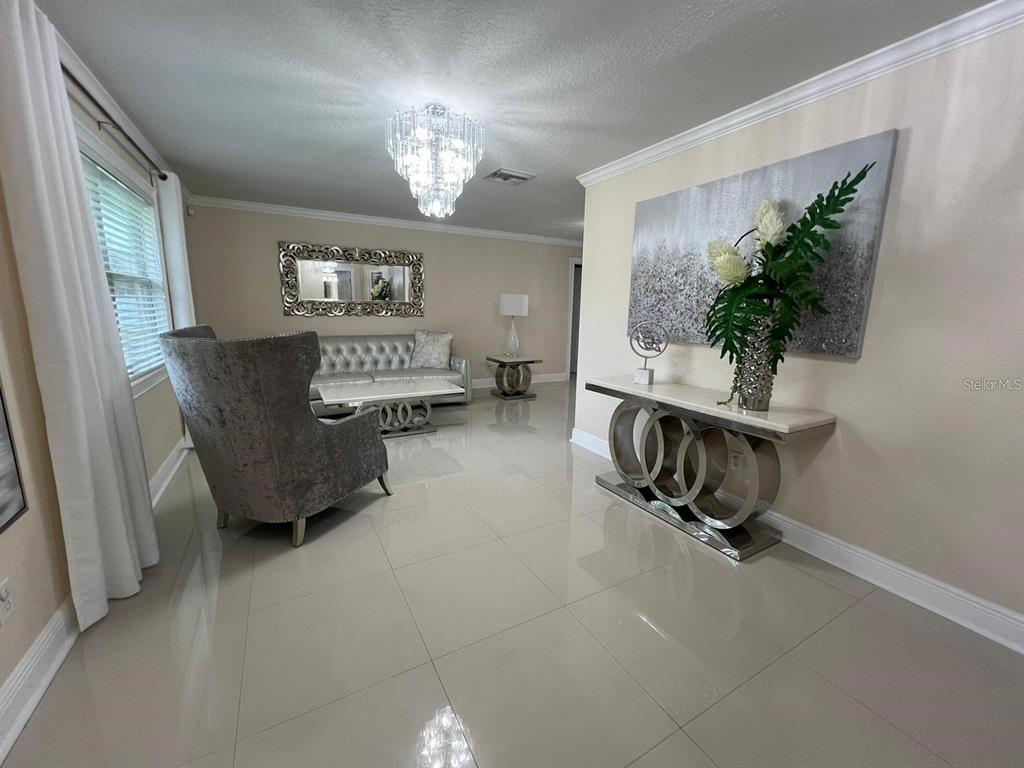 5602 Joyner Road Tampa, FL 33624 - Photo 24 of 28 a living room with furniture and a chandelier