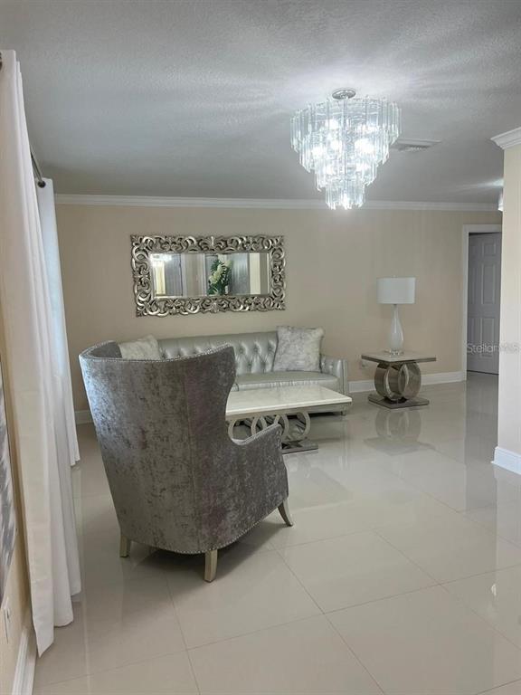 5602 Joyner Road Tampa, FL 33624 - Photo 26 of 28 a living room with furniture and chandelier