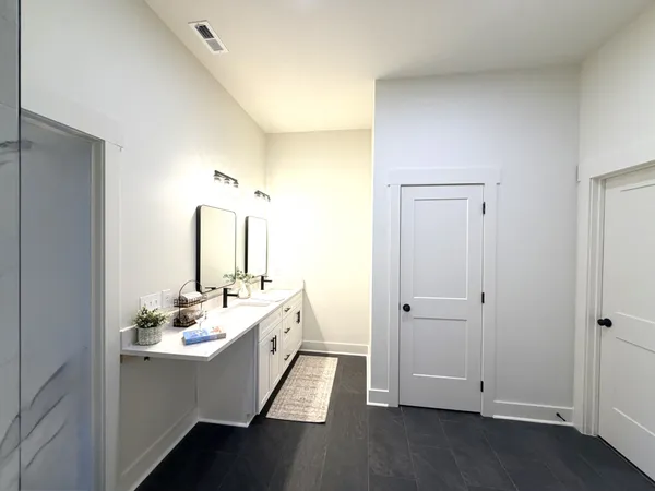 a bathroom with a double vanity sink and mirror