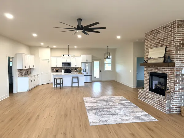 a living room with stainless steel appliances kitchen island furniture and a fireplace