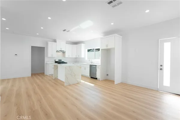 a view of a kitchen with refrigerator and wooden floor