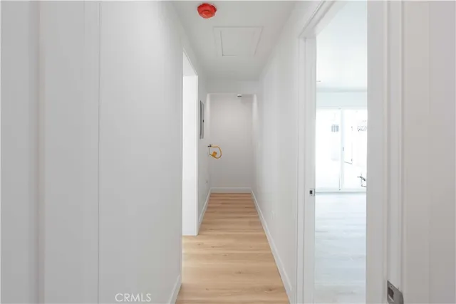 a view of a hallway with wooden floor and closet