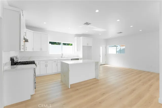 a kitchen with granite countertop white cabinets and white appliances