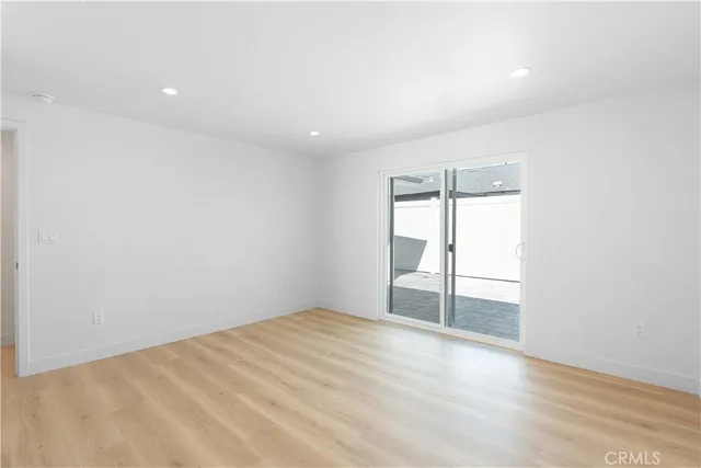 an empty room with wooden floor and sliding door
