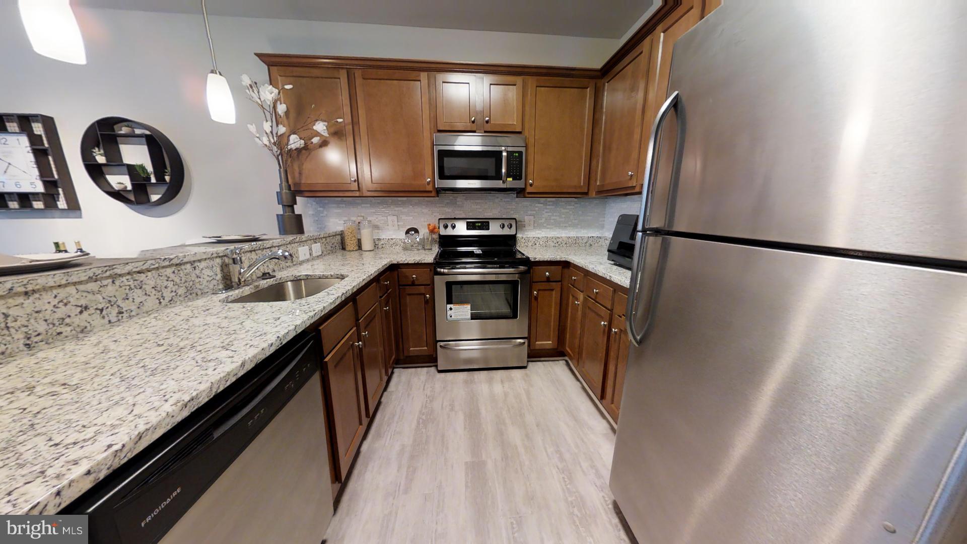 1262 Talbert Street Southeast, Unit B Washington, DC 20020 - Photo 6 of 18 a kitchen with granite countertop a refrigerator a stove and a sink