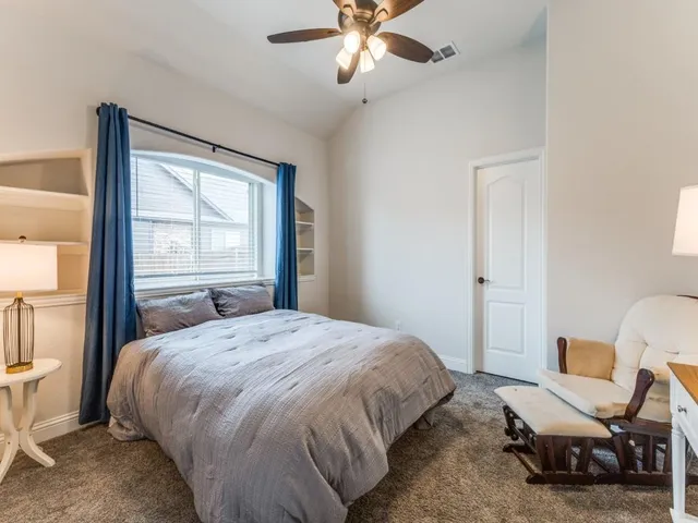 a bedroom with a bed a chair and a large window