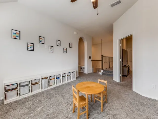 a living room with furniture pool table and chairs