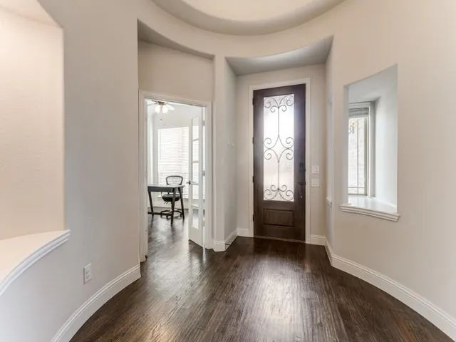 an empty room with wooden floor and a window