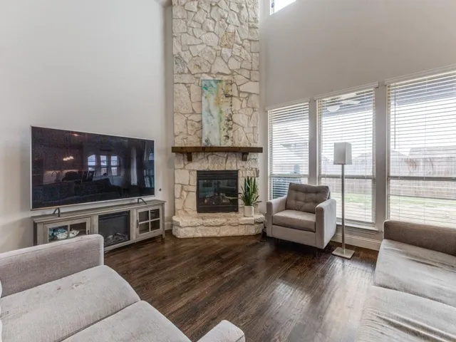 a living room with furniture a flat screen tv and a fireplace