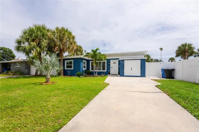 a front view of a house with a yard and trees