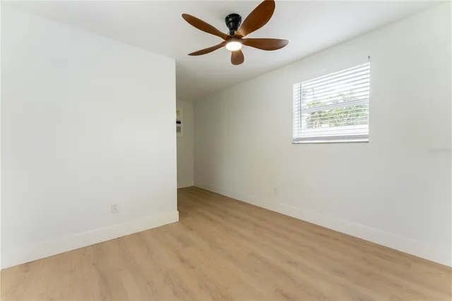 an empty room with a window and a fan