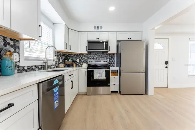 a kitchen with stainless steel appliances a refrigerator sink and cabinets