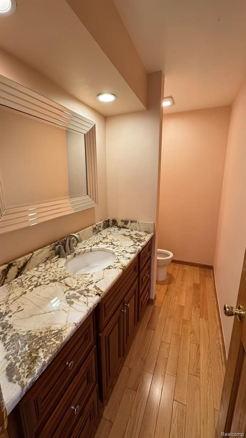 3440 Salem Drive Rochester, MI 48306 - Photo 16 of 33 Bathroom featuring a vanity with an integrated sink, patterned countertop, dark wood-finish cabinetry, and a framed mirror