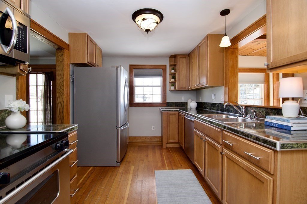 a kitchen with stainless steel appliances a stove cabinets and wooden floor