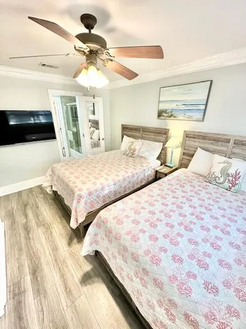 a bedroom with two large bed and a chandelier