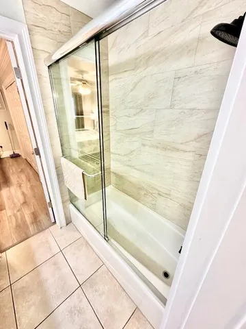 a bathroom with a bathtub and next to a window