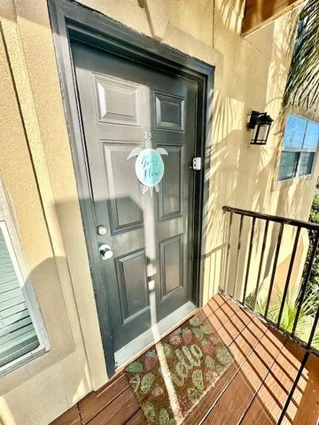a view of a hallway with wooden floor and door