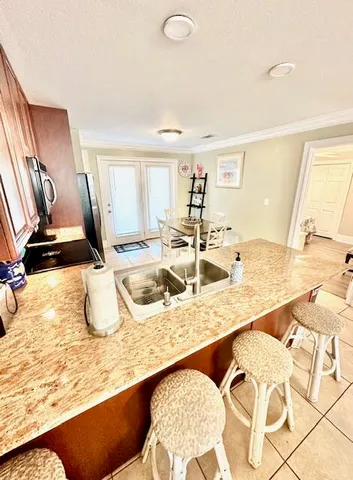 a kitchen with granite countertop a sink and a white cabinets
