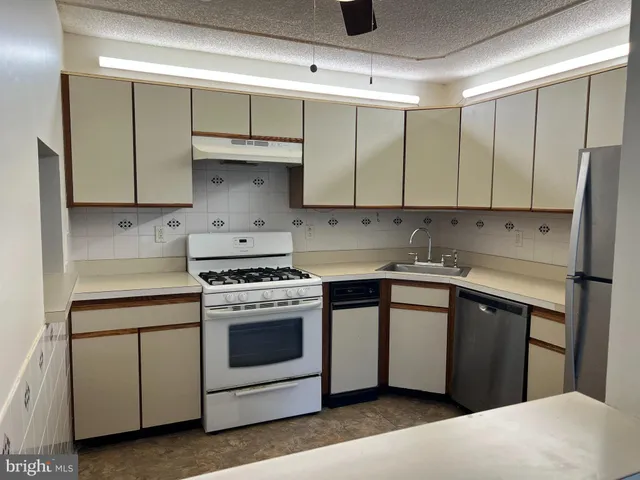 a kitchen with stainless steel appliances white cabinets and a sink