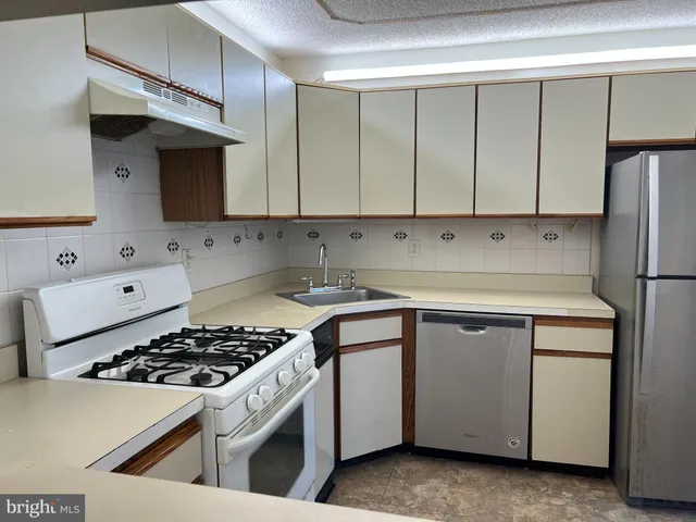 a kitchen with cabinets appliances a sink and a stove