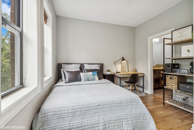 a bedroom with a bed and wooden floor