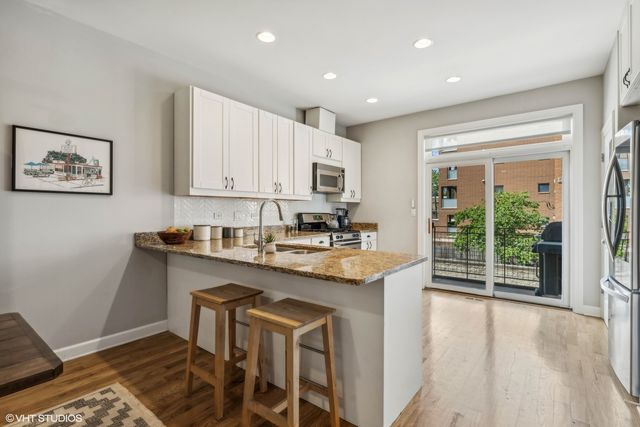 a kitchen with stainless steel appliances granite countertop a stove a sink and a microwave