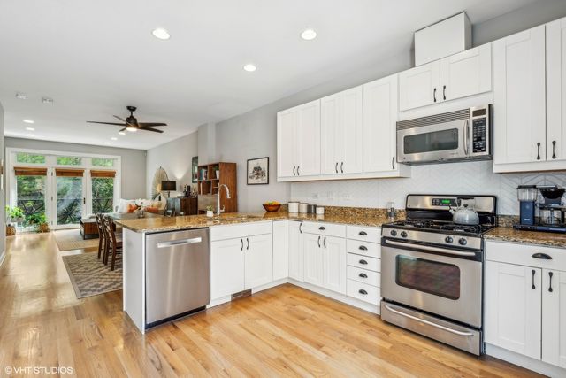 a kitchen with stainless steel appliances granite countertop a stove and white cabinets