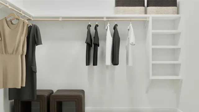 a view of walk in closet with clothes and shoes