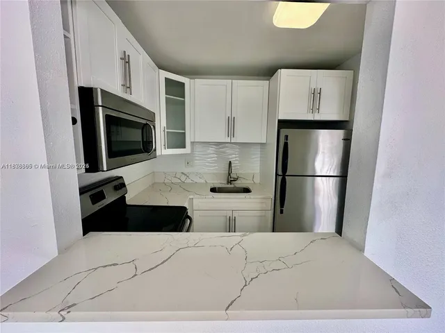 a front view of a house with large trees