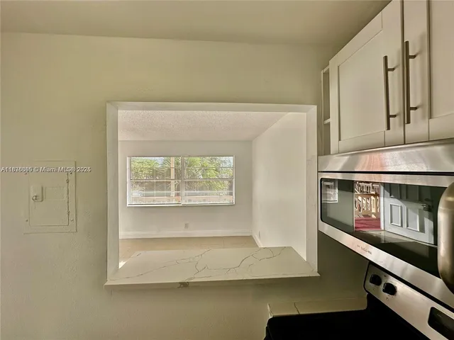 a kitchen with a refrigerator sink and cabinets