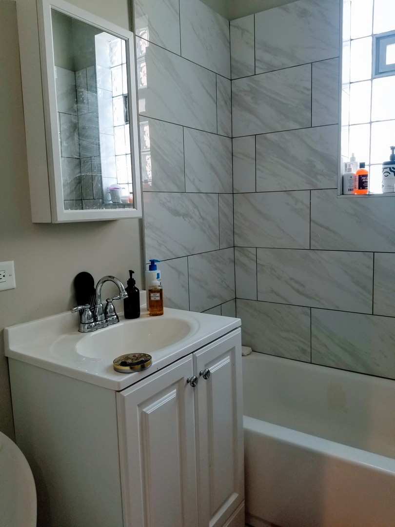 4764 North Virginia Avenue, Unit 112 Chicago, IL 60625 - Photo 9 of 12 a bathroom with a sink a toilet and a bathtub