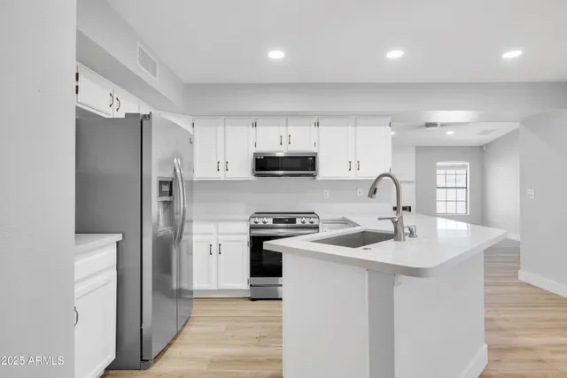 a kitchen with stainless steel appliances granite countertop a refrigerator sink and stove