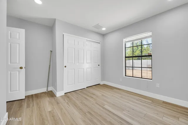a view of a room with wooden floor and window in it