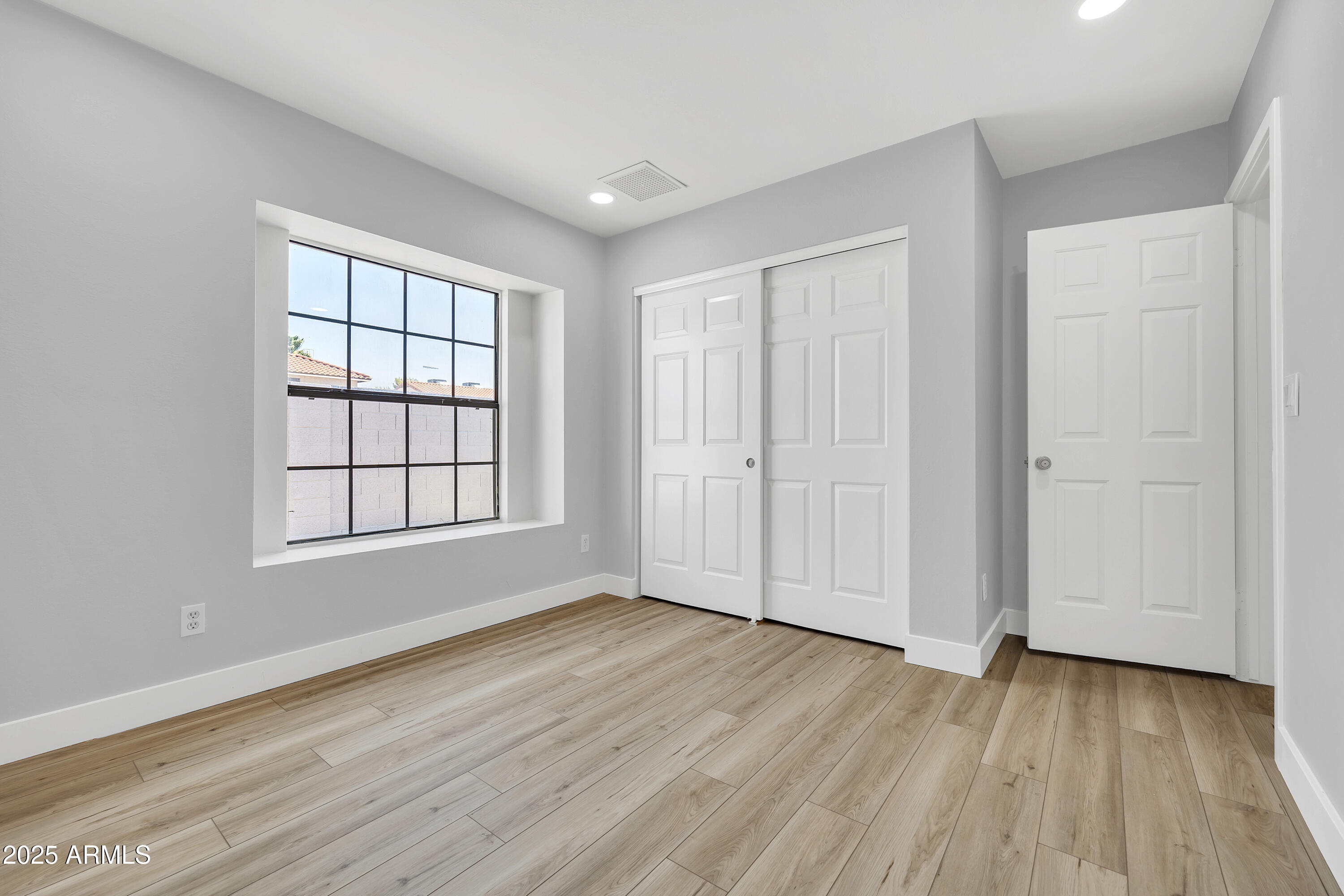 5302 West Cheryl Drive Glendale, AZ 85302 - Photo 29 of 39 an empty room with wooden floor and windows