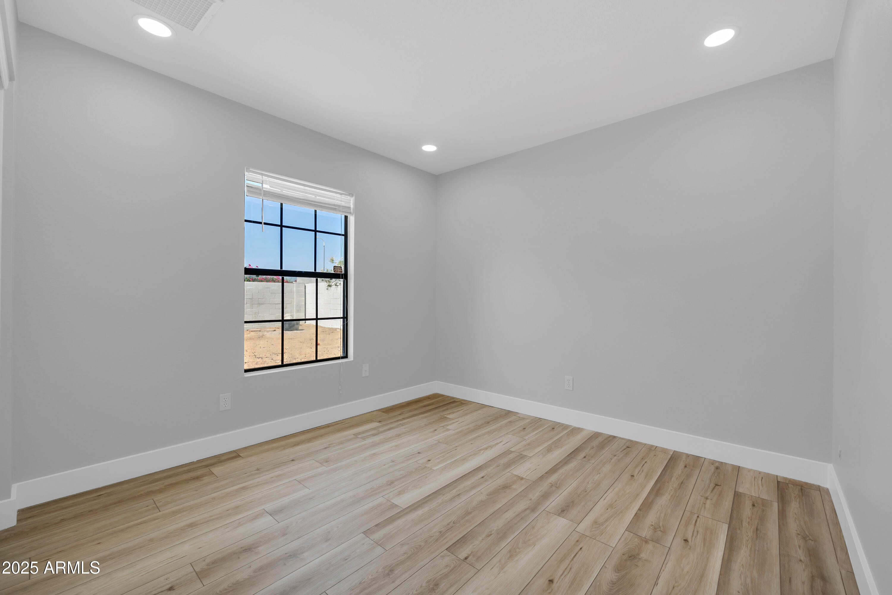 5302 West Cheryl Drive Glendale, AZ 85302 - Photo 32 of 39 an empty room with wooden floor and windows