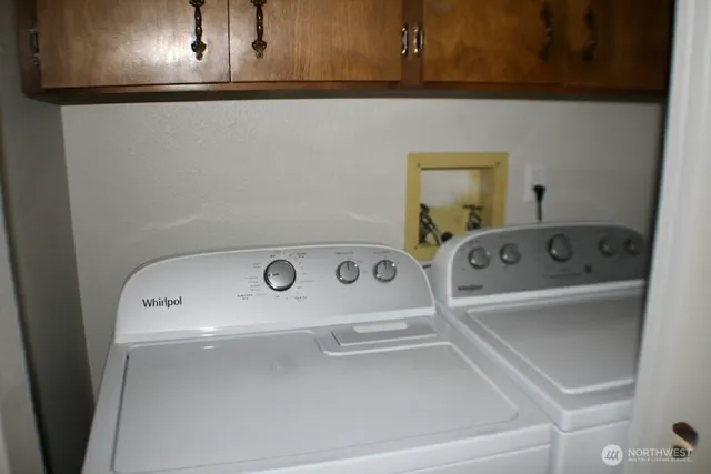 a living room with a couch and a flat tv screen next to a window