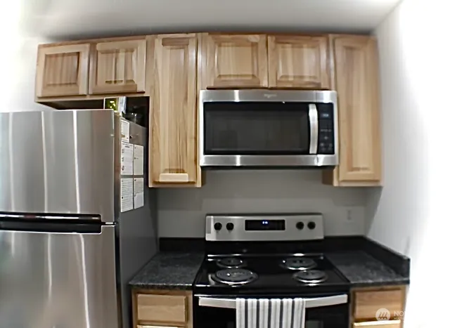 a kitchen with granite countertop a stove and a microwave