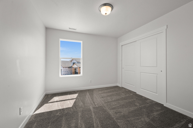 1554 Pheasant Road Eagle Mountain, UT 84005 - Photo 23 of 29 Unfurnished bedroom featuring dark colored carpet and a closet