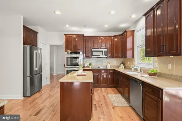 a kitchen with stainless steel appliances granite countertop a refrigerator stove microwave and sink
