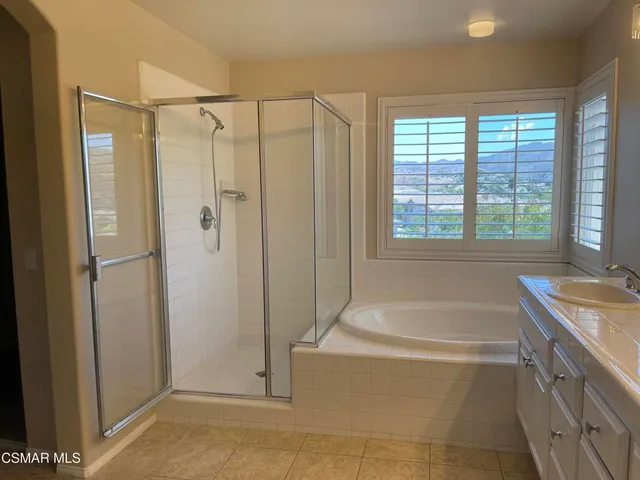a spacious bathroom with a tub shower and sink
