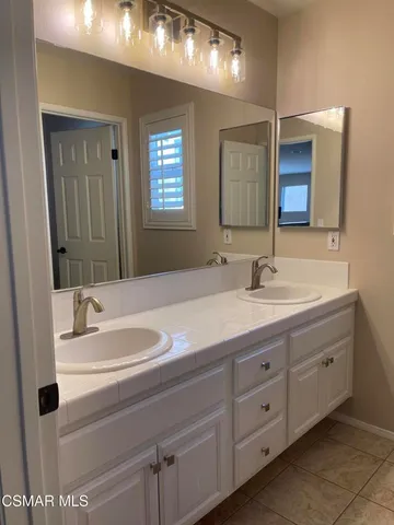 a bathroom with a double vanity sink and a mirror