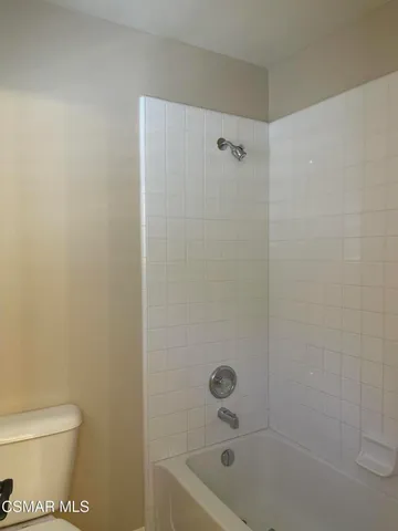 a bath room with a toilet and a bath tub