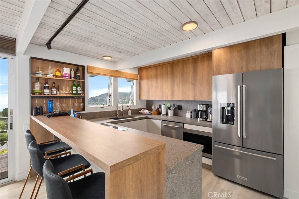 945 Coast View Drive Laguna Beach, CA 92651 - Photo 20 of 40 a kitchen with kitchen island a counter and a refrigerator