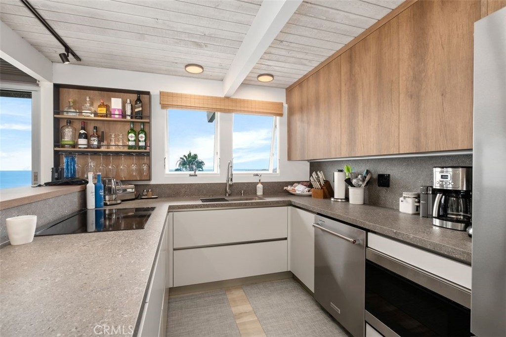 945 Coast View Drive Laguna Beach, CA 92651 - Photo 21 of 40 a kitchen with stainless steel appliances a sink window and cabinets