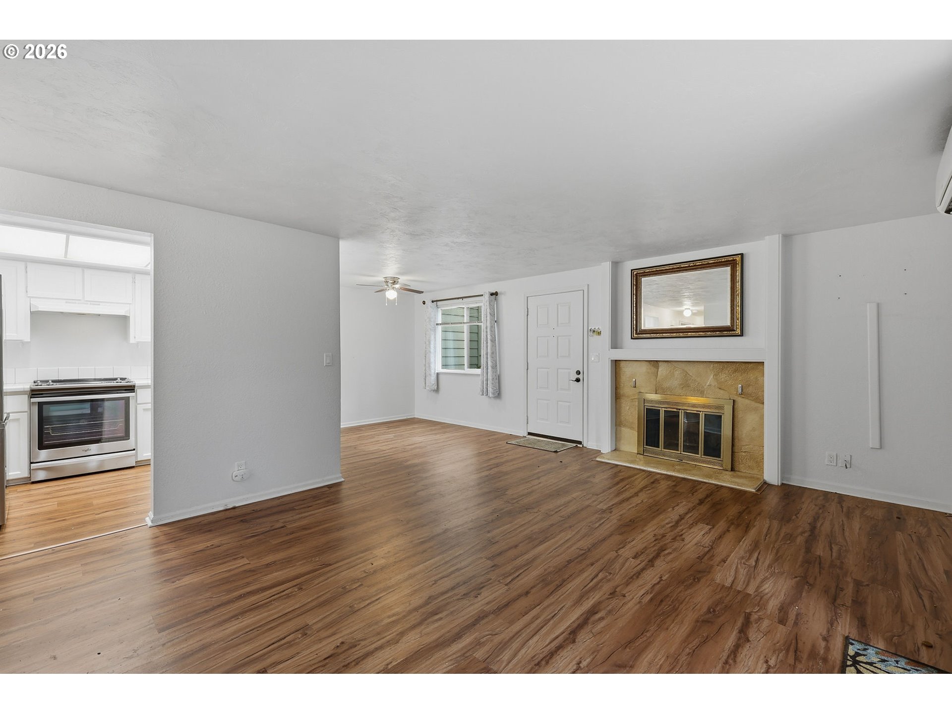 2001 Lake Isle Terrace Eugene, OR 97401 - Photo 5 of 36 a view of an empty room with wooden floor fireplace and a window