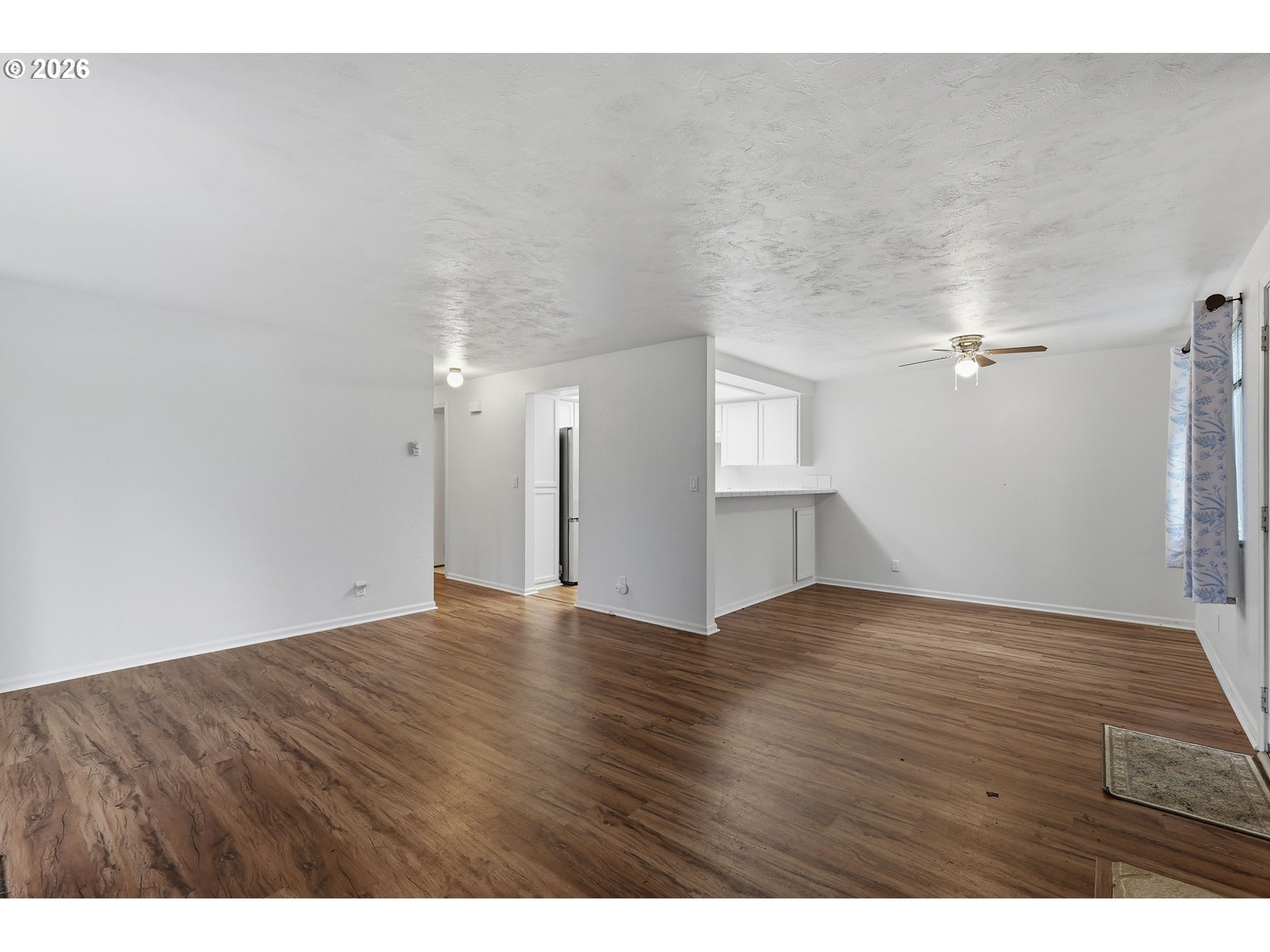 2001 Lake Isle Terrace Eugene, OR 97401 - Photo 8 of 36 a view of an empty room with wooden floor and a ceiling fan