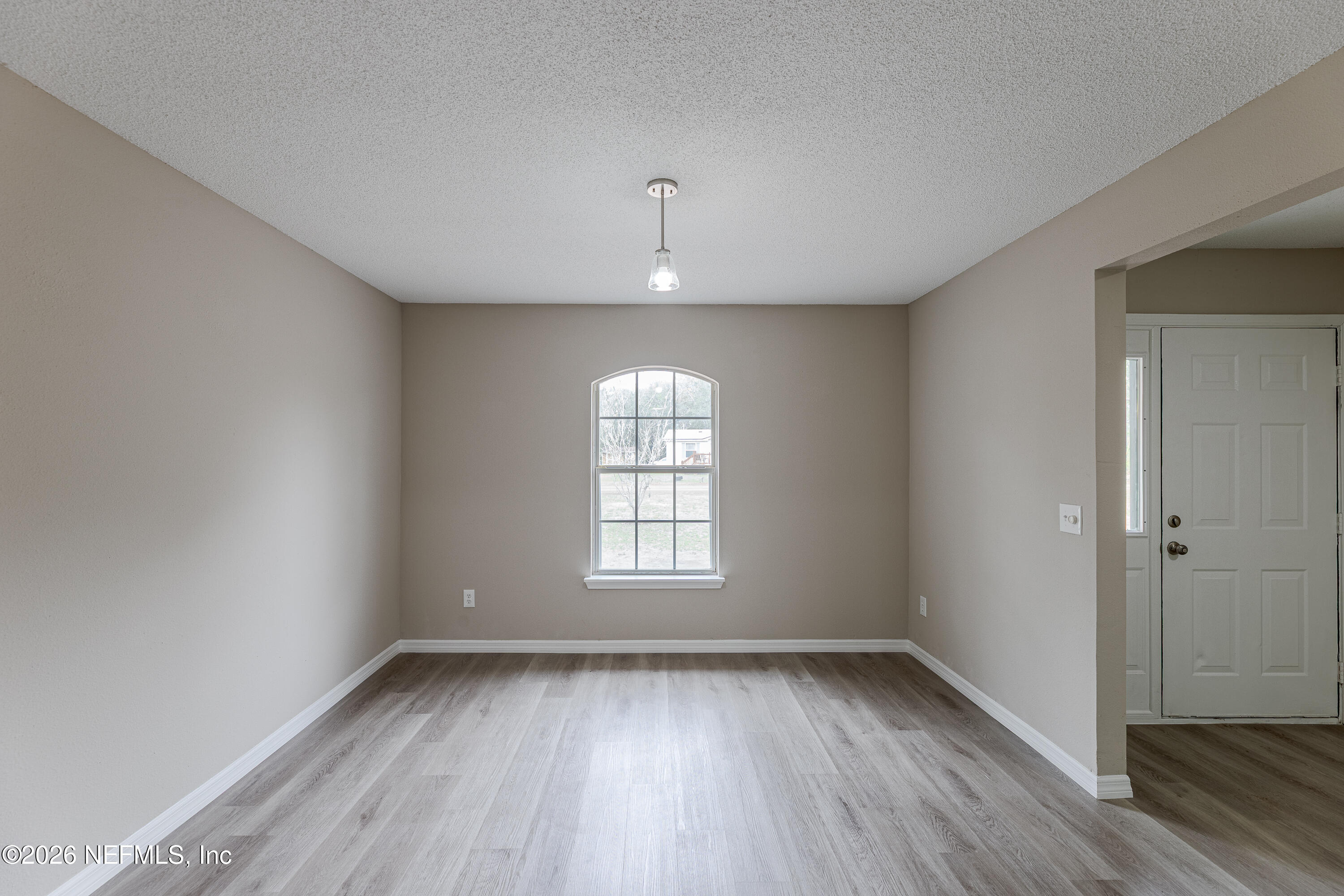 67104 Elnora Lane Yulee, FL 32097 - Photo 11 of 39 wooden floor in an empty room with a window