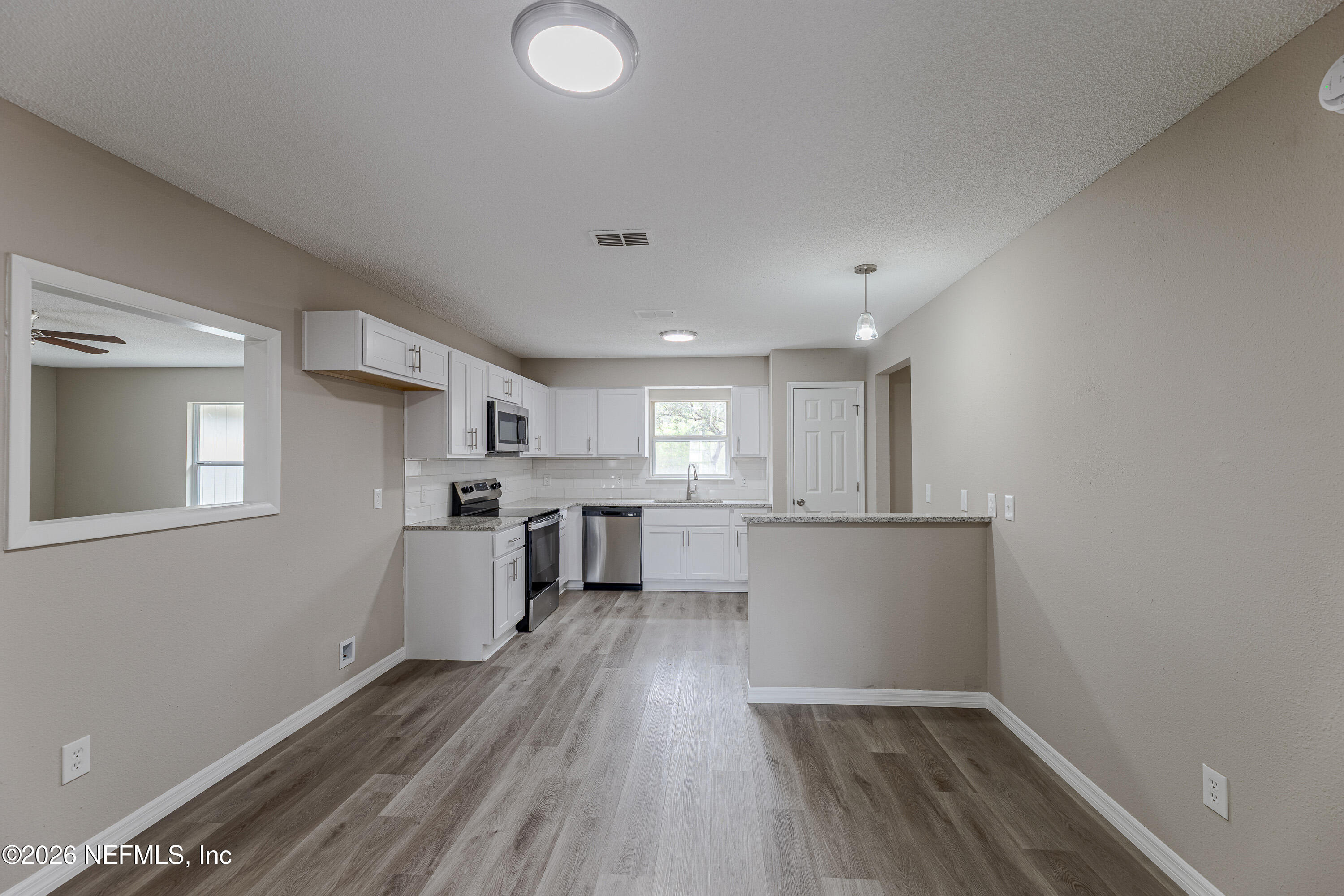 67104 Elnora Lane Yulee, FL 32097 - Photo 12 of 39 a view of kitchen with window and wooden floor