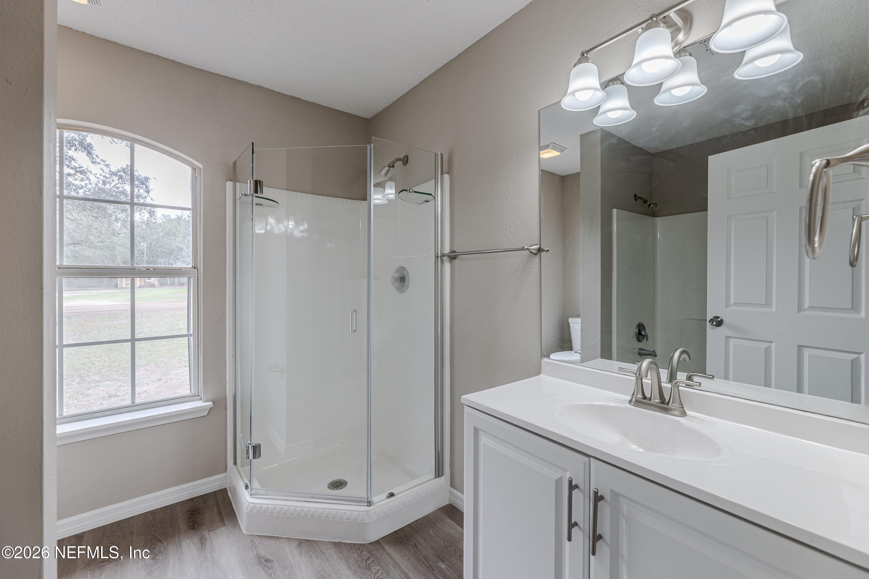 67104 Elnora Lane Yulee, FL 32097 - Photo 23 of 39 a bathroom with a sink a large mirror and shower